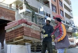 Dos albañiles controlan un palé de ladrillos y cemento              en una obra de la capital. La foto es de archivo. / VICENTE VICENS / AGM