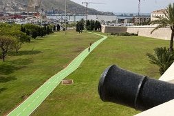 El carril bici, visto desde la Muralla del Mar, con un cañón en primer plano.
