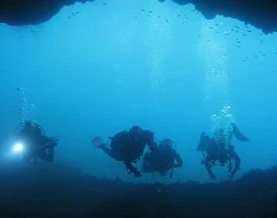 Cuatro buceadores pasan por una de las cuevas de las aguas de Cabo Tiñoso. / A. R.