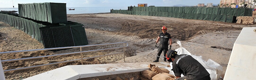 Miembros de la Unidad Militar de Emergencias de Valencia colocan sacos de tierra para crear un muro para contener el agua en la desembocadura de la                   rambla de Las Culebras./ PACO ALONSO / AGM