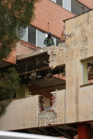 Un operario trabaja en la demolición de una de las pasarelas del viejo pabellón maternal de La Arrixaca. ::                             SATURNINO ESPÍN