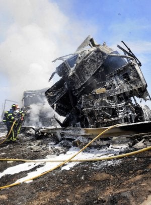 Los bomberos, durante la extinción de los dos camiones, ayer, en Murcia. ::                             VICENTE VICÉNS/AGM