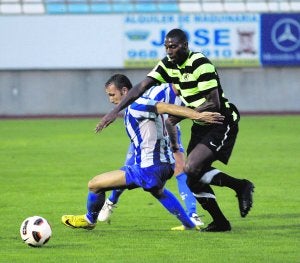 Un jugador del Hércules acosa a un rival del Lorca Atlético en el partido de anoche. ::                             SONIA M. LARIO / AGM