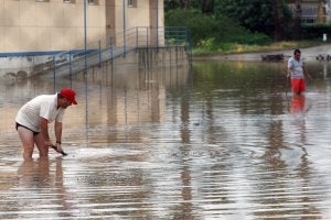 Dos hombres en la rambla de Las Culebras de Águilas, totalmente anegada tras la tromba de agua caída el martes. ::                             EDU BOTELLA / AGM