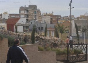 Tres personas pasan junto a un poste con dos cámaras de videovigilancia, en el parque urbano y arqueológico del Molinete. ::                             ANTONIO GIL / AGM