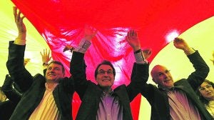 Artur Mas, junto a Josep Antoni Duran i Lleida, extiende una 'senyera' ayer en el mitin de CiU en Mataró. ::
ALBERTO ESTÉVEZ / EFE