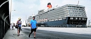Turistas frente al 'Queen Elizabeth', atracado en un muelle alicantino el año pasado. :: D. Madrigal