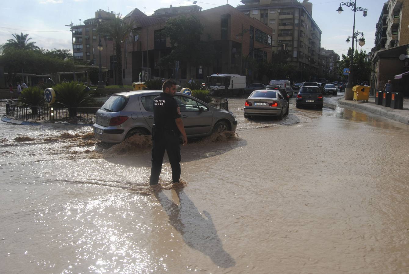 Un agente de policía dirige el tráfico, afectado por las lluvias. 