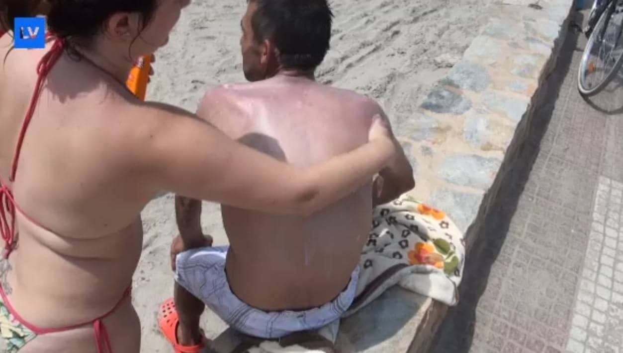 Una pareja se echa crema en la playa de Lo Pagán. 