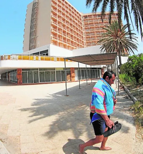 Un turista pasa junto al hotel, cerrado a cal y canto. :: a. gil
