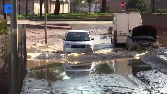Un coche pasa por una zona inundada en la pedanía de Churra. 