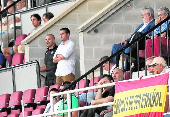 Julio César Ribas, mánager general del FC Cartagena, en el vomitorio del palco, acompañado por Javi Manzano y observado por Florentino Manzano desde su butaca, ayer en el estadio Cartagonova. :: j. m. rodríguez / agm