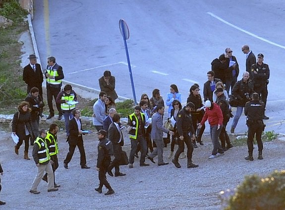 Uno de los seis imputados, a la derecha de la foto con el rostro cubierto por una braga y un gorro blanco, da explicaciones durante la reconstrucción de los hechos. 