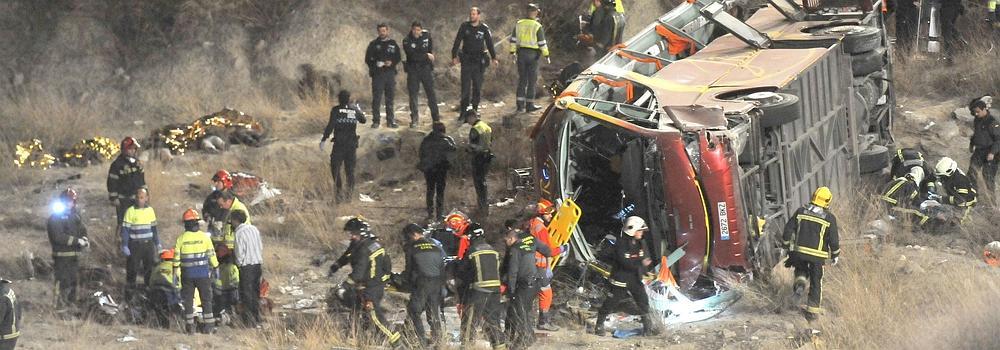 Decenas de miembros de los equipos de emergencias, auxiliando a los heridos en torno al autobús accidentado.
