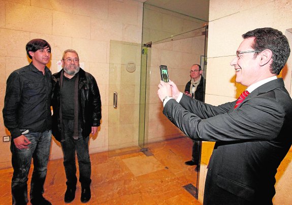 El consejero de Presidencia, José Gabriel Ruiz, fotografía con un móvil al secretario general de UGT, Cándido Méndez, y a un asistente al acto que se celebró ayer en la sede del sindicato. 