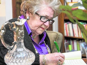 María Teresa Cervantes firmando un ejemplar de su libro en su casa de Cartagena.