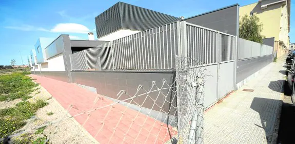 Vista general del Centro de Atención a la Infancia de Nueva Cartagena, con el vallado y la parcela llena de maleza. agm
