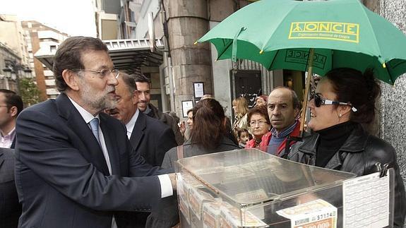 Mariano Rajoy saluda a una vendedora de cupones de la ONCE.