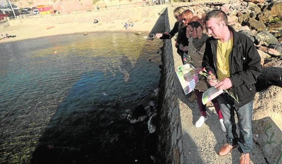 Los familiares de Diego Pérez lanzan claveles al mar en su memoria. 