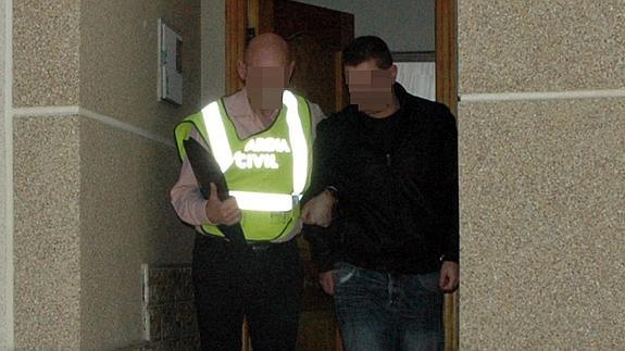 Un agente de la Guardia Civil arresta al joven en su vivienda.