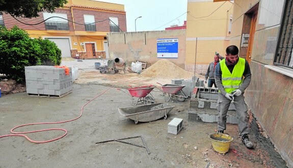 Dos obreros trabajando, ayer a mediodía, en una de las plazas del barrio de El Calvario que están siendo remodeladas. 