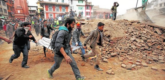 Un grupo de voluntarios, ayer, evacuan a una de las víctimas del terremoto que sacudió Katmandú. 