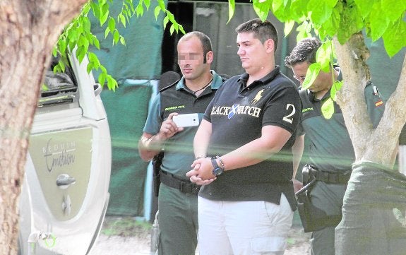 Un agente de la Guardia Civil custodia dentro del camping a uno de los sospechosos. 