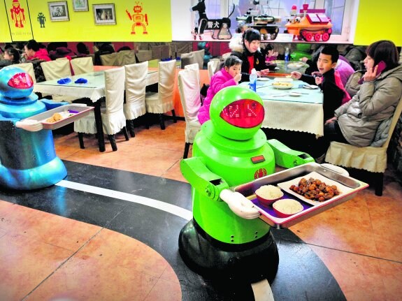 Los camareros del Robot Restaurant de Hardin, en la provincia china de Heilongjiang. Abajo, un 'paciente' de un dentista en prácticas; una máquina que imita el galope de un caballo y 'El increíble hombre biónico' del Museo Smithsonian de Washington. 
