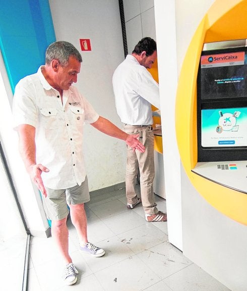 Gumersindo, ayer, indicando las dimensiones del cartón que utilizaba para dormir en un cajero del barrio de El Carmen. 
