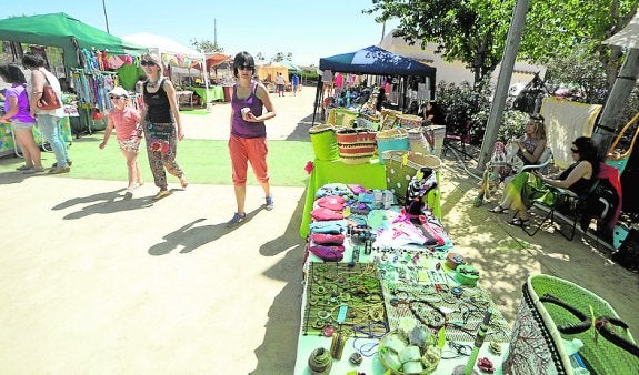 Un grupo de vecinos pasea entre los estand de artesanos. agm