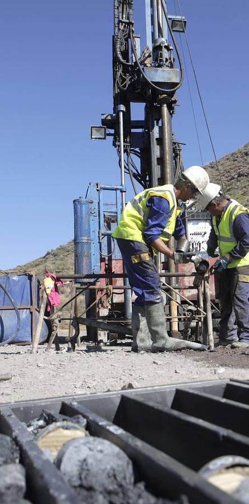 Dos de los trabajadores que manejan la perforadora extraen, ayer, un tubo con muestras de las rocas del subsuelo. 