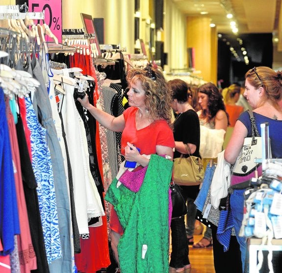 Varias clientas miran la ropa rebajada en busca de chollos. 