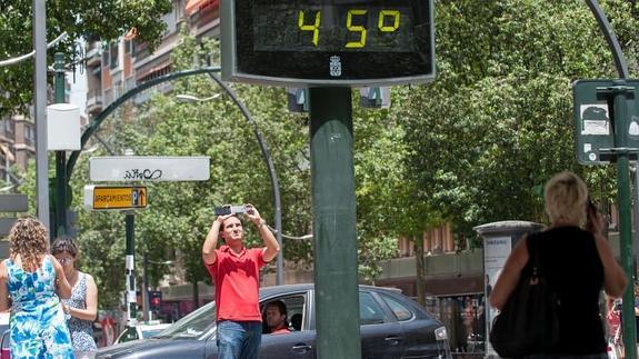 Un hombre fotografía un termómetro en la Gran Vía de Murcia. 