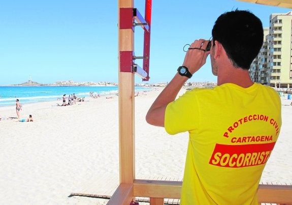 Un socorrista vigila a los bañistas en una playa de La Manga. 