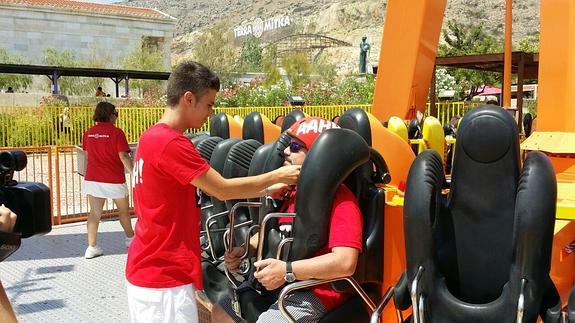 Un trabajador coloca los sistemas de seguridad a un cliente antes en una de las atracciones.