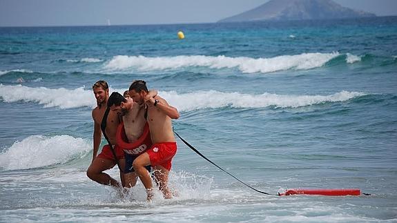 Dos socorristas ayudan a salir del agua a un 'nadador cansado'. 