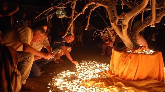 Vecinos y turistas colocan velas alrededor del Árbol de los Deseos, en la madrugada de este domingo en Aledo.