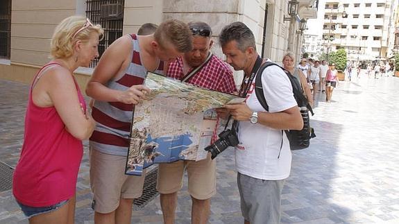 Unos turistas consultan un mapa en Cartagena. 