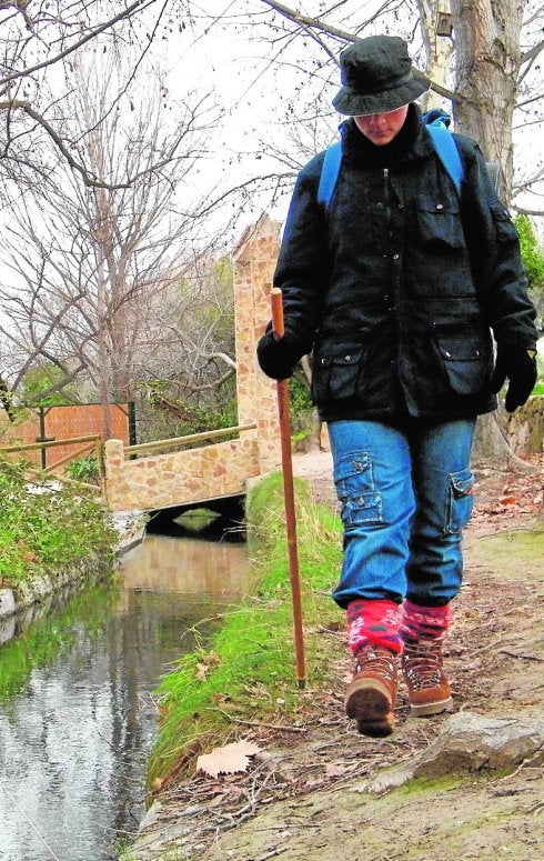 Una peregrina realiza el camino por las Fuentes del Marqués.