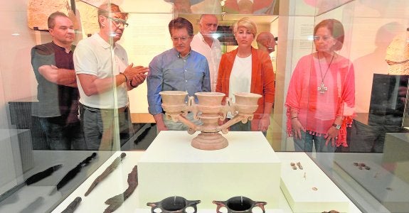 La consejera y el alcalde escuchan las explicaciones del director del Museo Arqueológico ante una de las vitrinas. 