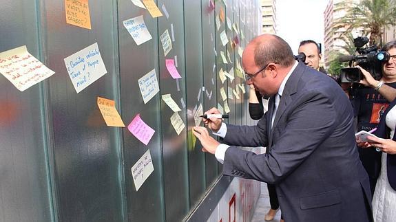 Pedro Antonio Sánchez escribe una sugerencia en el recién instalado panel de la avenida de la Libertad. 