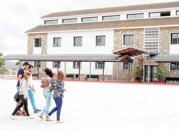 Cinco jóvenes atraviesan la plaza del campus de la UCAM en Los Dolores. 