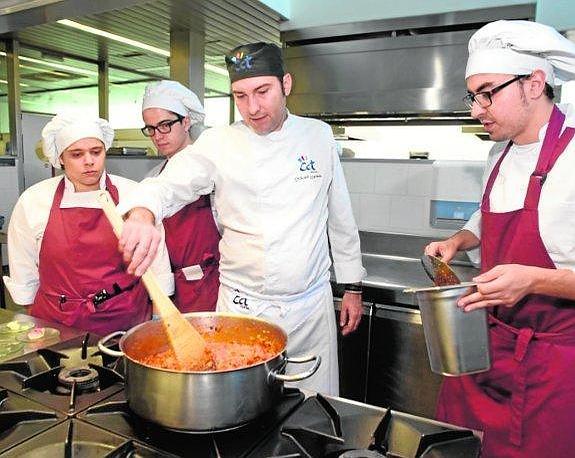 David López enseña a tres de sus alumnos a preparar una base para uno de los platos.