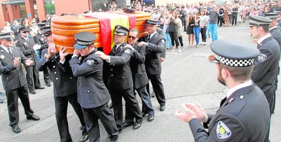 Policías locales sacan del tanatorio el féretro, mientras otros le hacen un pasillo y le aplauden. 