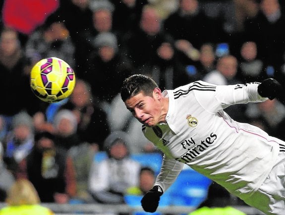 El futbolista colombiano James Rodríguez, del Real Madrid, cabecea en un partido. 