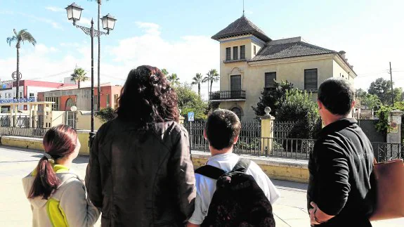 Unos padres y sus hijos observan, a la salida del colegio, la casa en la que fue detenido el presunto pederasta.