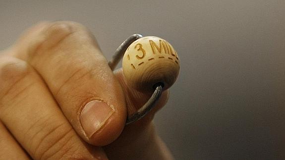 Un funcionario de Loterías y Apuestas del Estado sostiene una de las bolas. 