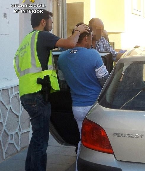 Agentes de la Guardia Civil con uno de los detenidos en la operación. 