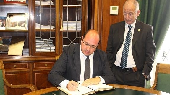 Sánchez firma en el libro de honor de la Diputación bajo la mirada de Gabriel Amat.