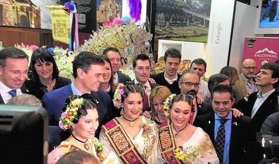 El secretario general del PSOE, Pedro Sánchez, se fotografía con la Reina y Damas de la Huerta en el pabellón de la Región en Fitur. 